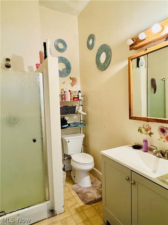 927 Avon Street Akron, OH 44310 - Photo 10 of 12 Bathroom featuring a shower stall with a frosted glass door, a white toilet, and a vanity with a white countertop and base cabinet