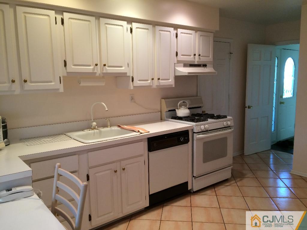 10 Carpender Road New Brunswick, NJ 08901 - Photo 5 of 25 a kitchen with granite countertop white cabinets and white appliances