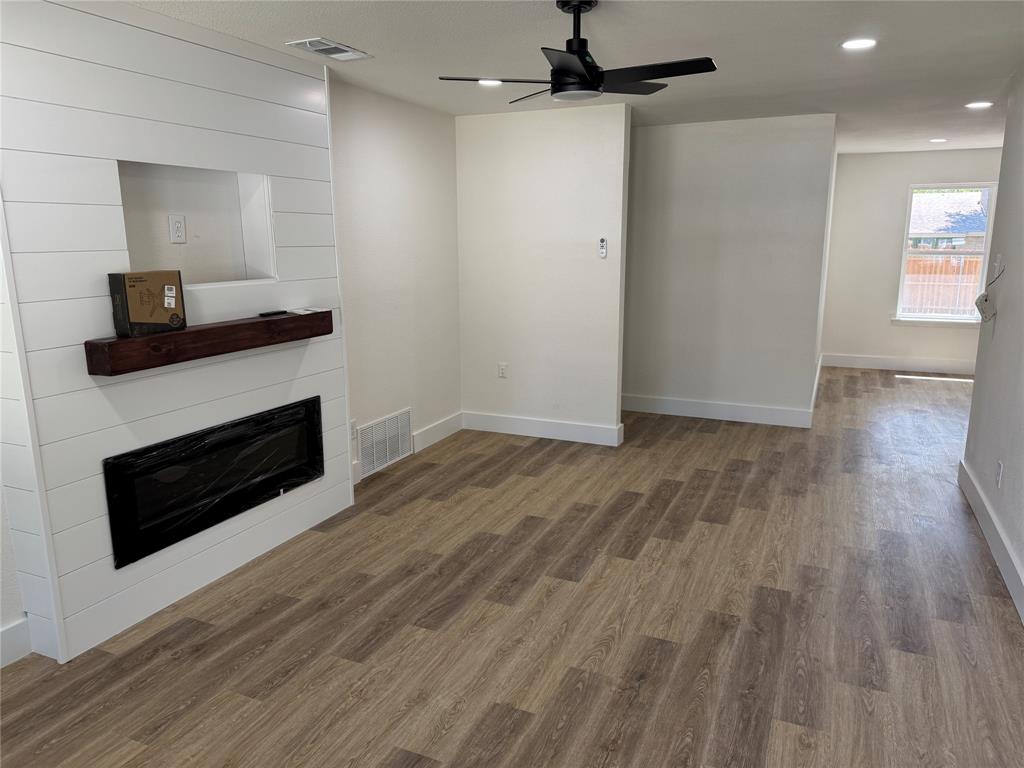 501 Cambridge Drive Richardson, TX 75080 - Photo 14 of 35 a view of a livingroom with wooden floor and a fireplace