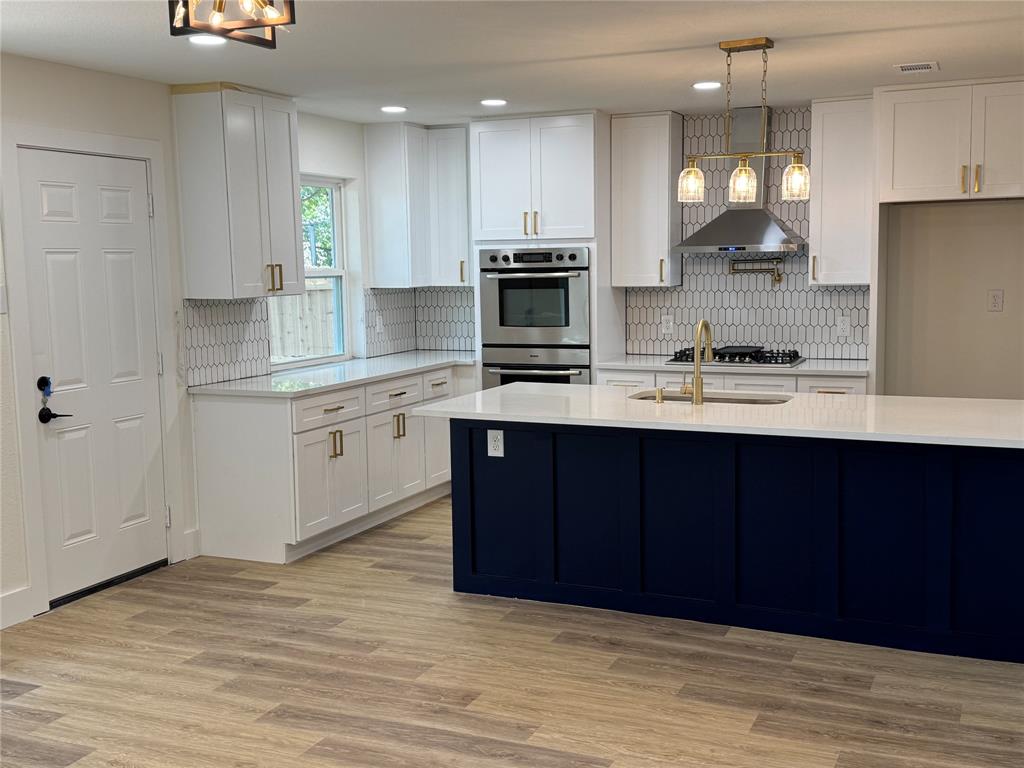 501 Cambridge Drive Richardson, TX 75080 - Photo 15 of 35 a kitchen with kitchen island granite countertop wooden cabinets and a sink