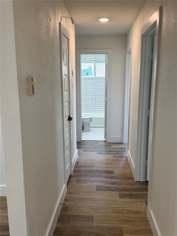 501 Cambridge Drive Richardson, TX 75080 - Photo 23 of 35 a view of a hallway with wooden floor and a bathroom