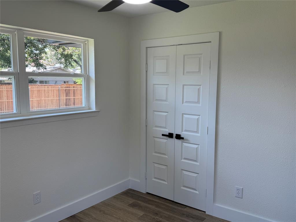 501 Cambridge Drive Richardson, TX 75080 - Photo 25 of 35 an empty room with wooden floor cabinet and windows