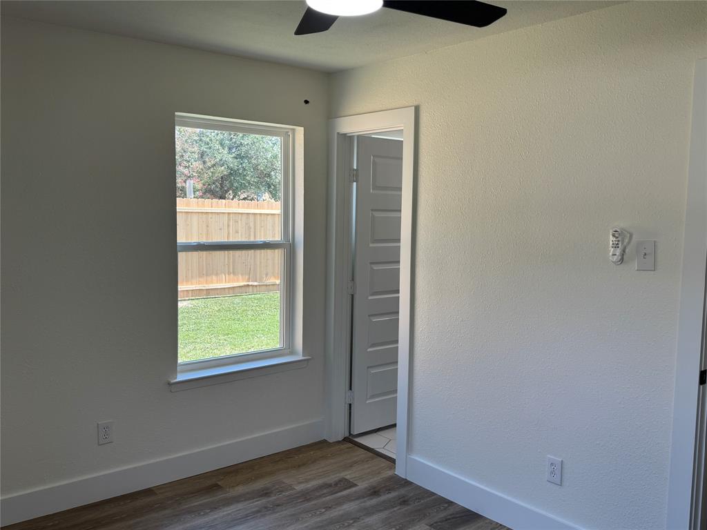 501 Cambridge Drive Richardson, TX 75080 - Photo 27 of 35 an empty room with wooden floor and windows