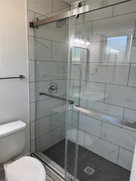 501 Cambridge Drive Richardson, TX 75080 - Photo 29 of 35 a bathroom with a toilet and shower