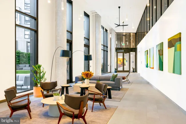 a living room with furniture and floor to ceiling windows