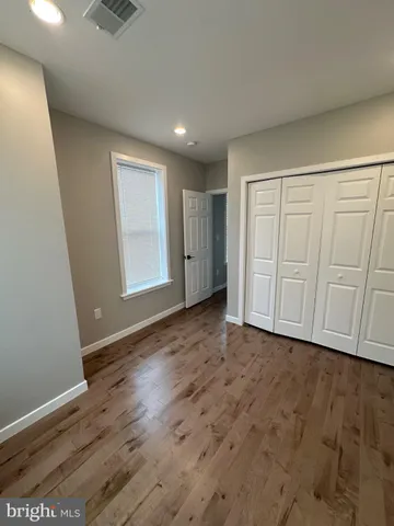 an empty room with wooden floor and cabinet