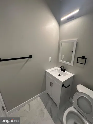 a bathroom with a sink toilet and mirror