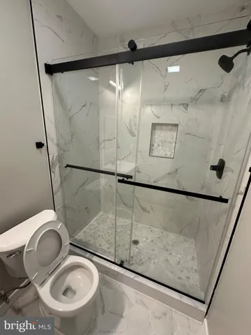 a bathroom with a granite countertop sink mirror and toilet