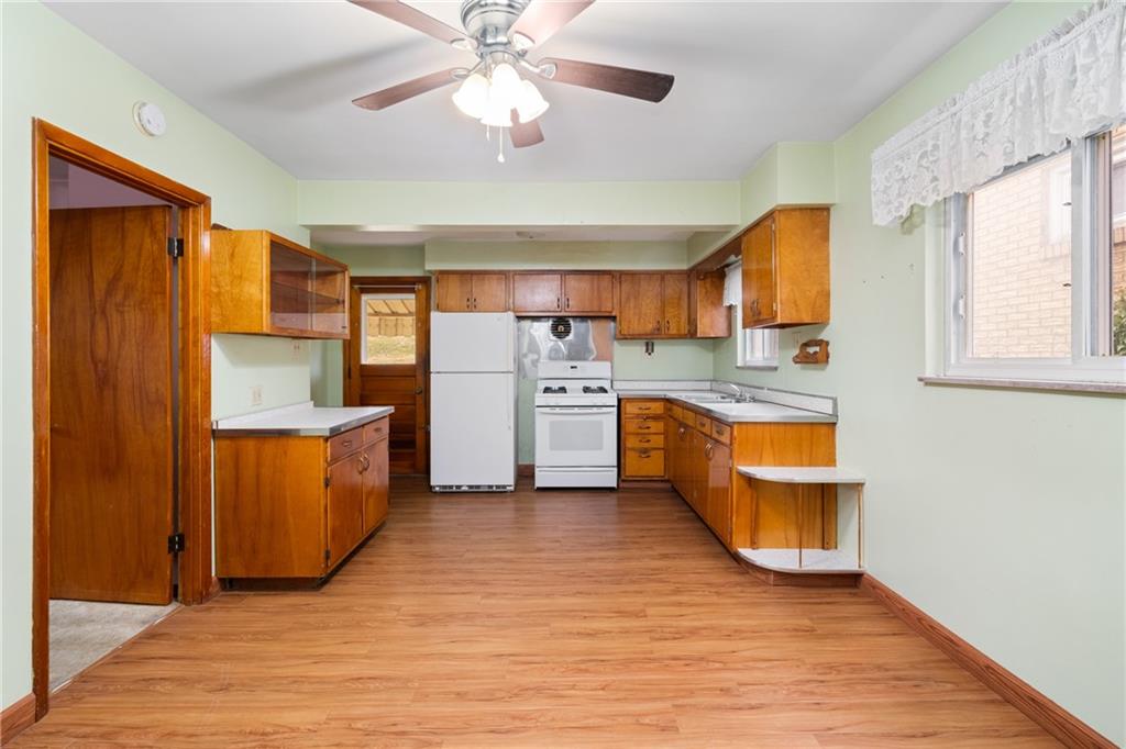 49 Gordon Street McKees Rocks, PA 15136 - Photo 13 of 27 a kitchen with stainless steel appliances granite countertop a sink a stove a refrigerator cabinets and wooden floor