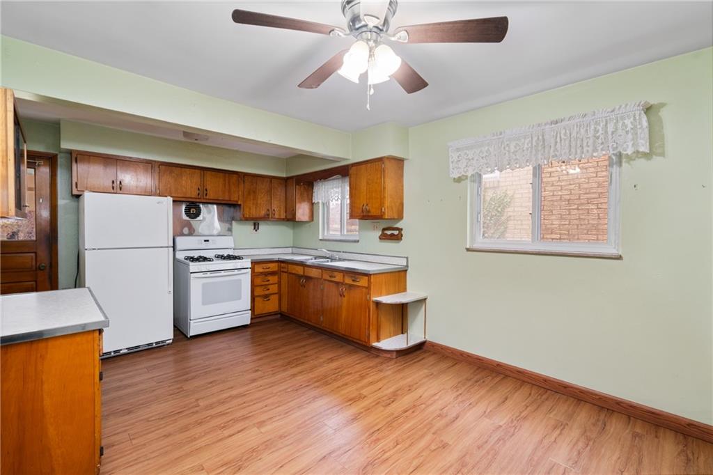 49 Gordon Street McKees Rocks, PA 15136 - Photo 10 of 27 a kitchen with stainless steel appliances a refrigerator a stove a microwave oven cabinets and wooden floor