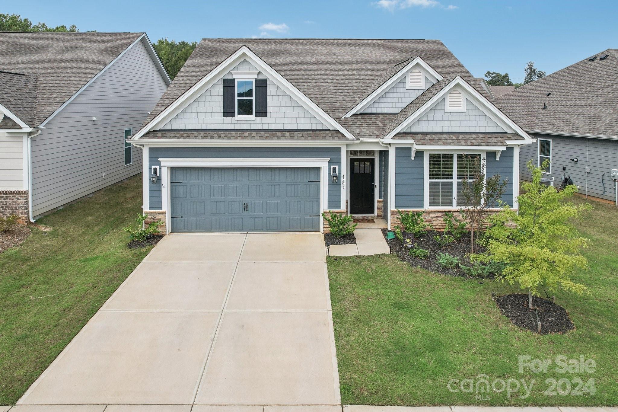 4203 Millstream Road Denver, NC 28037 - Photo 23 of 31 a front view of a house with a garden and plants