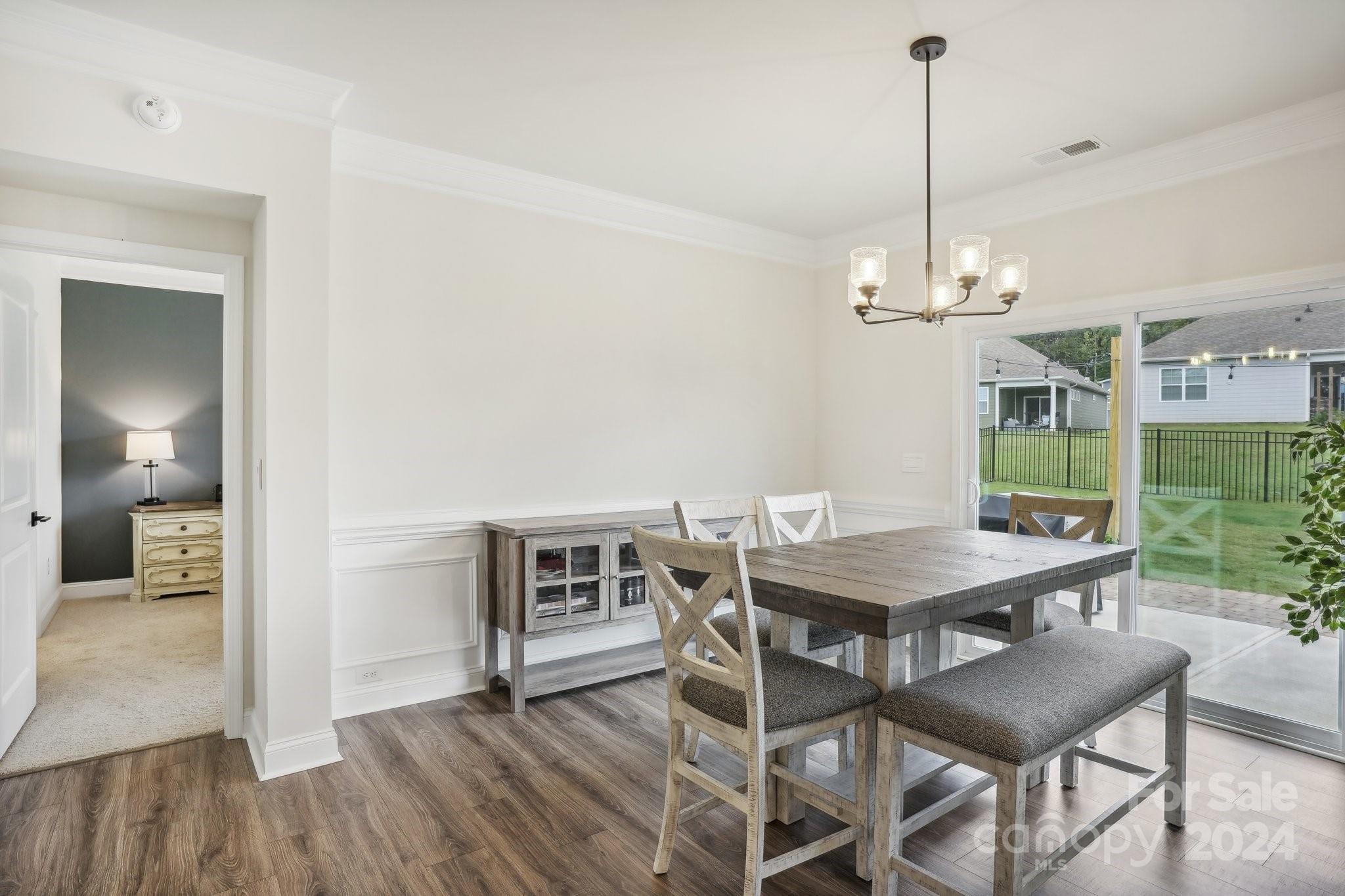 4203 Millstream Road Denver, NC 28037 - Photo 5 of 31 a view of a dining room and livingroom with furniture wooden floor a chandelier