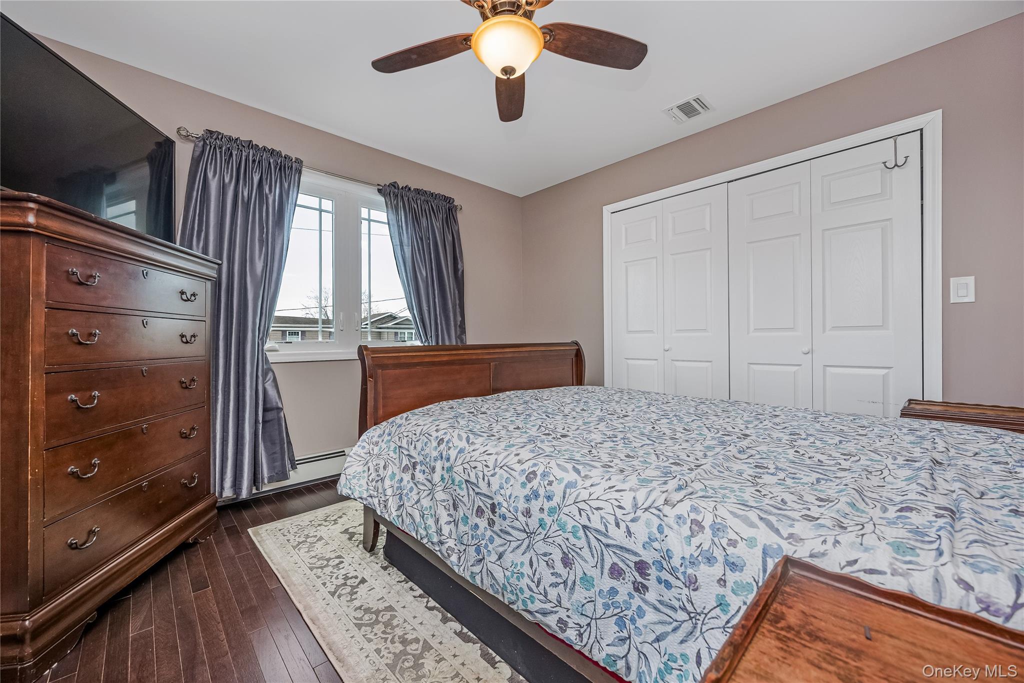 25 Cape Road Amityville, NY 11701 - Photo 14 of 30 a bedroom with a bed and a flat tv screen on dresser