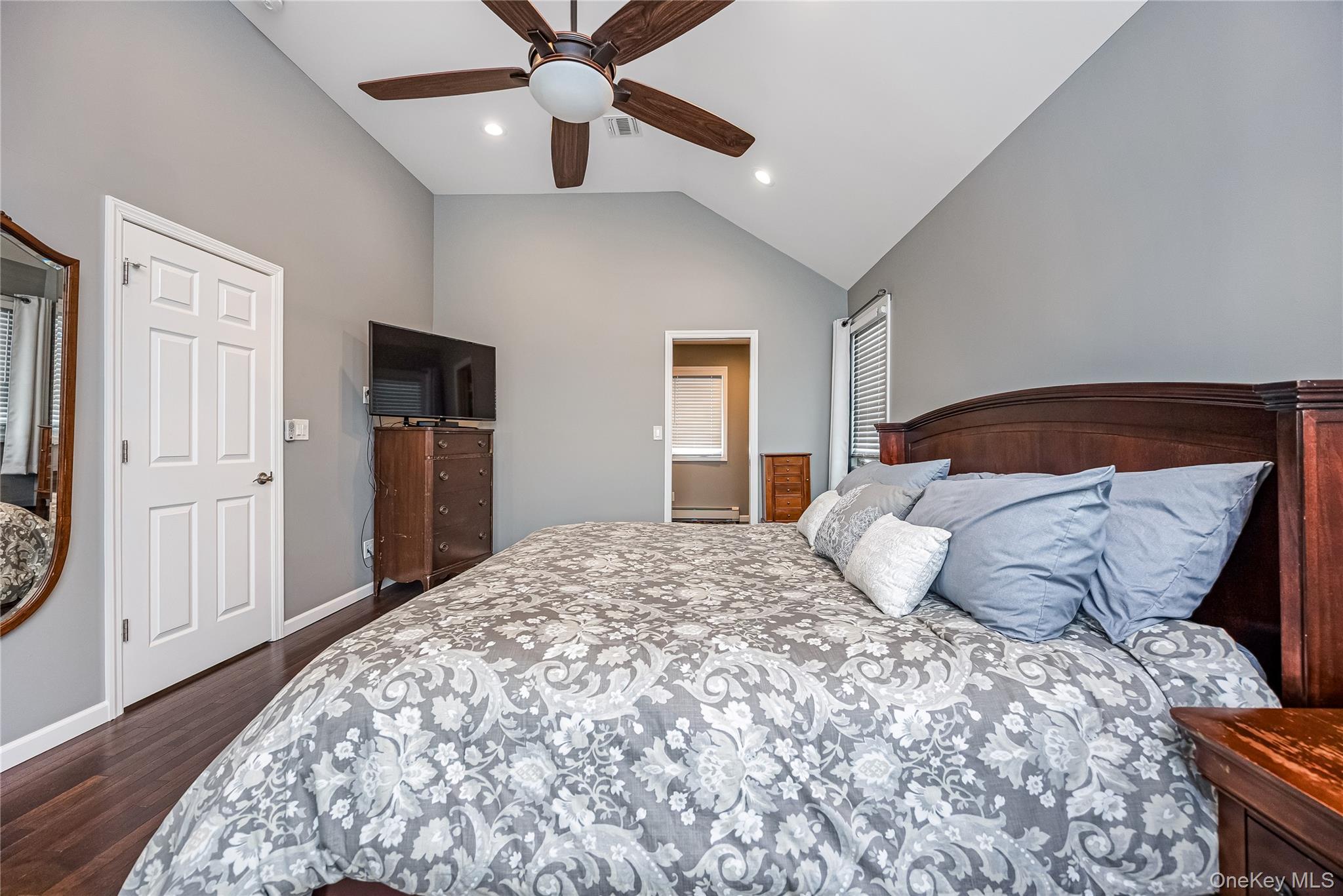 25 Cape Road Amityville, NY 11701 - Photo 16 of 30 a bedroom with a large bed and a chandelier