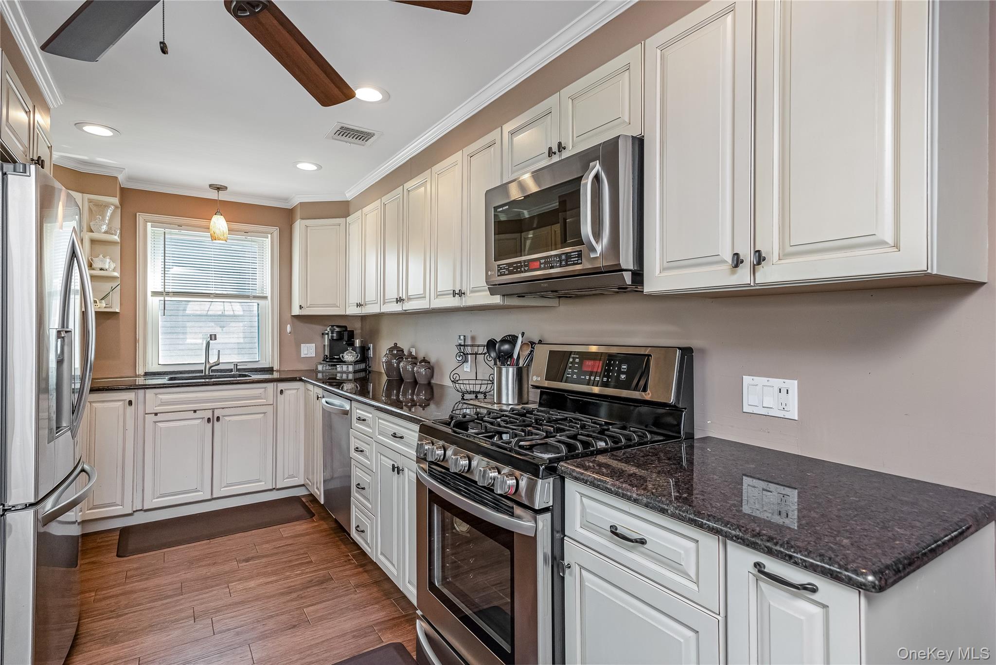 25 Cape Road Amityville, NY 11701 - Photo 10 of 30 a kitchen with stainless steel appliances granite countertop a stove a sink and a microwave