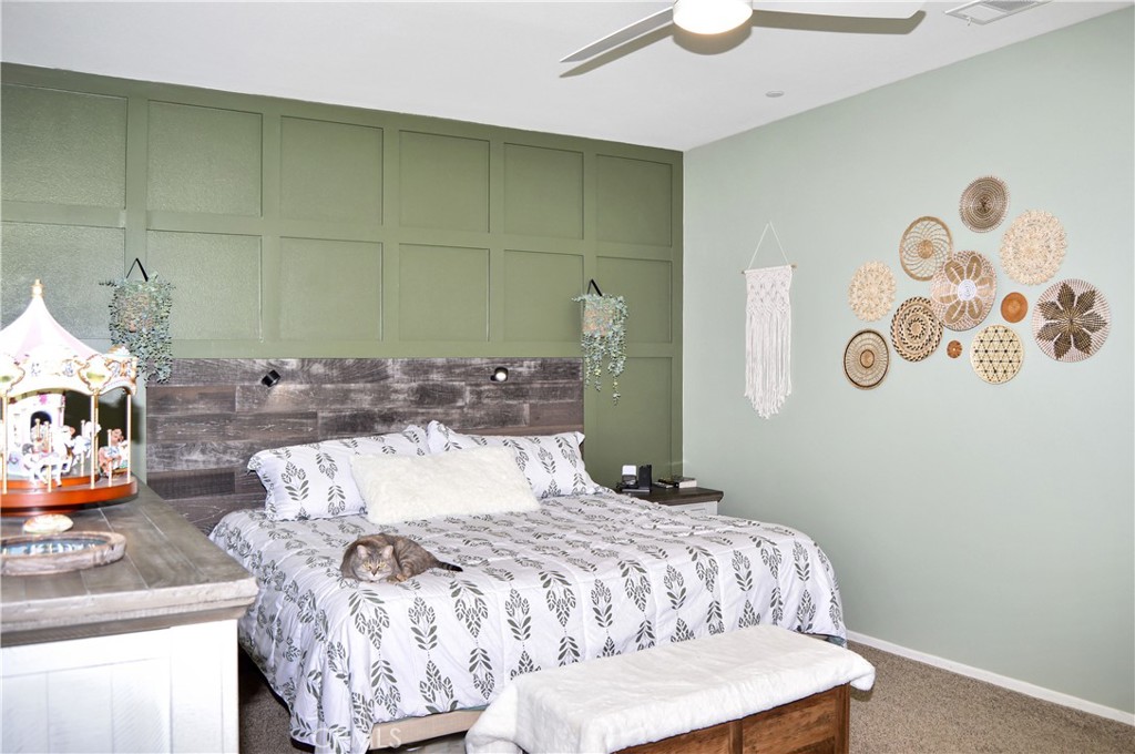 166 Fox Lane Calimesa, CA 92320 - Photo 33 of 76 Inviting Main Bedroom Suite with Custom Headboard with Reading Lights, Matching TV Surround with Shelving, Wood Panel Accents, a Ceiling Fan, and Cozy Carpeting