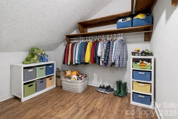 a view of walk in closet with clothes and shoes