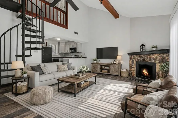 a living room with furniture a flat screen tv and a fireplace