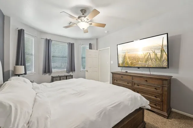 a bedroom with a bed and a ceiling fan