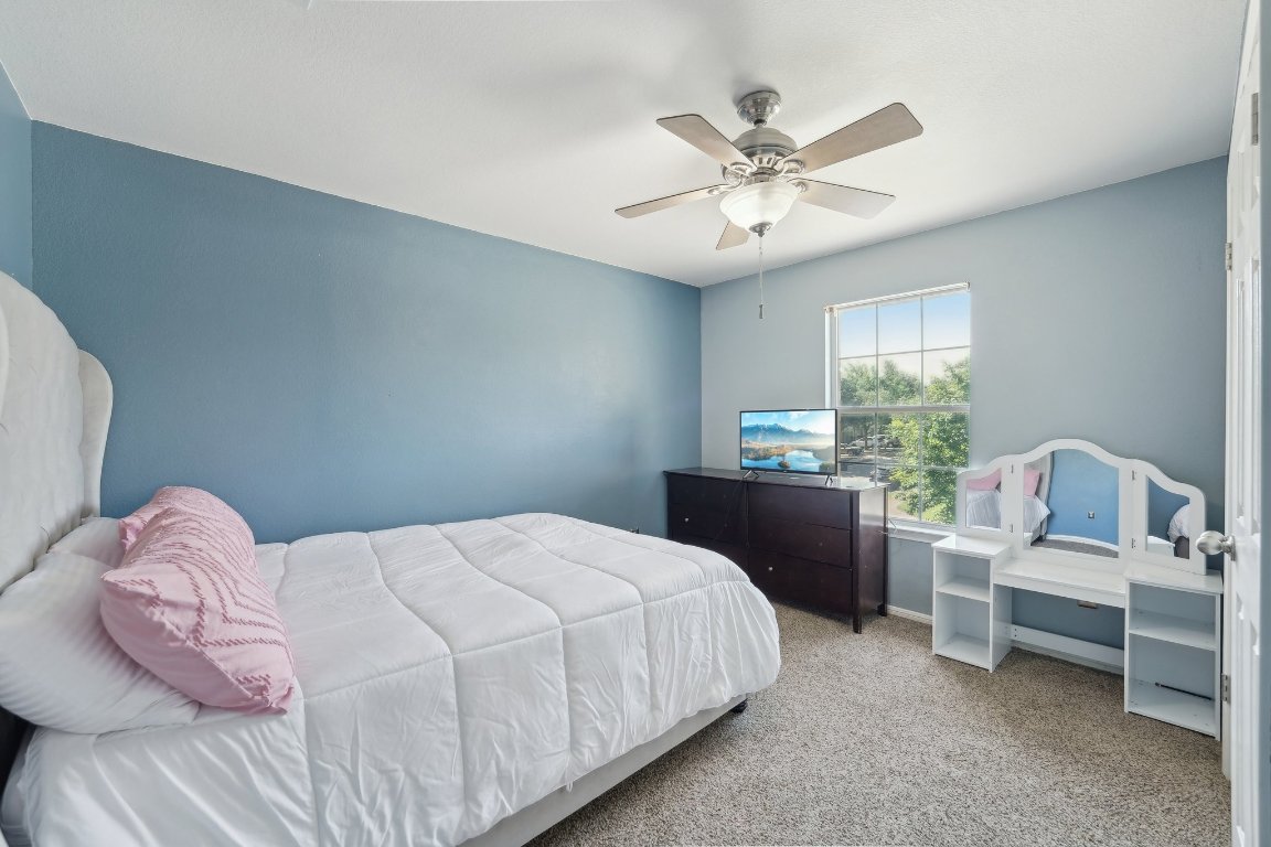 504 Chaparral Drive Leander, TX 78641 - Photo 25 of 34 a bedroom with a bed and a chandelier