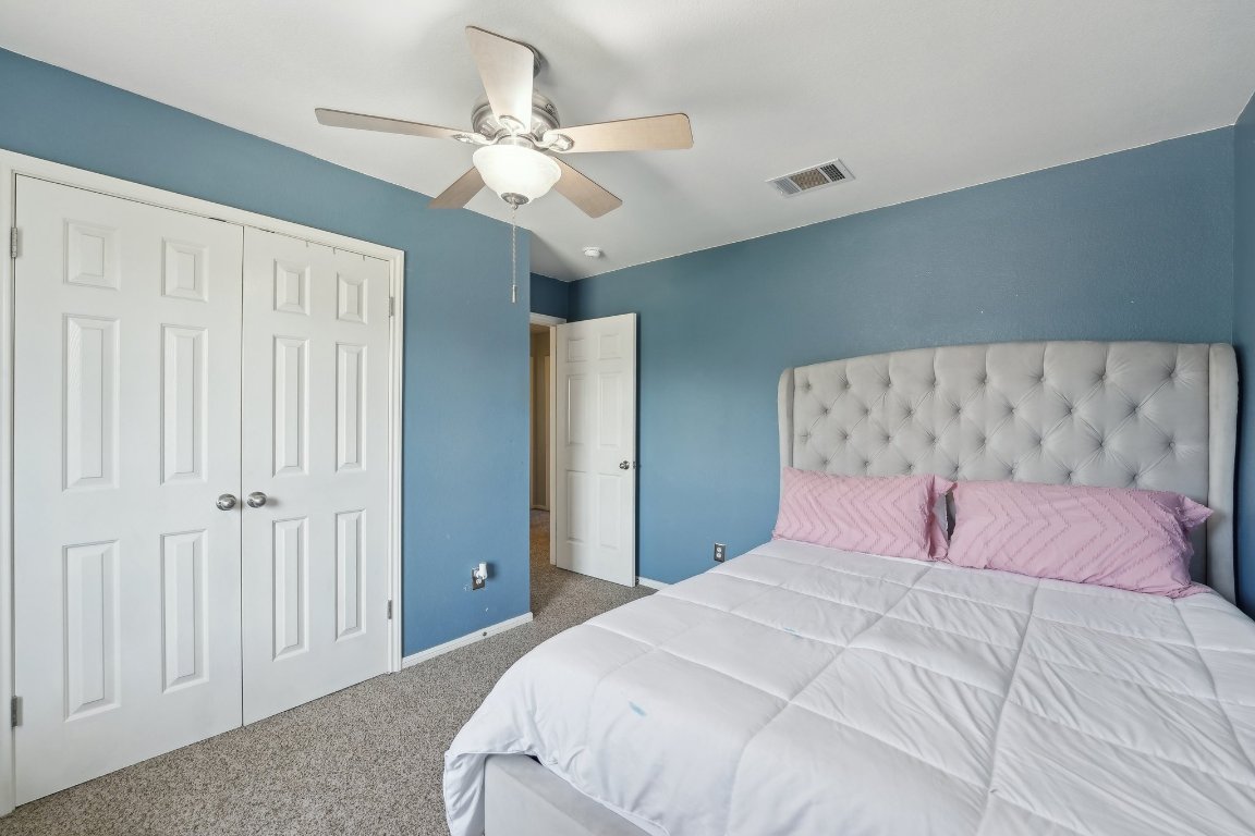 504 Chaparral Drive Leander, TX 78641 - Photo 26 of 34 a bedroom with a large bed and a chandelier