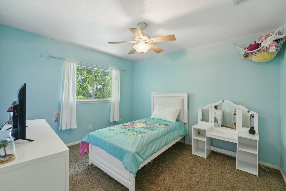 504 Chaparral Drive Leander, TX 78641 - Photo 29 of 34 a bedroom with a bed and a chandelier