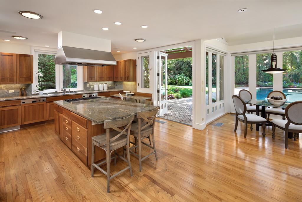 10 Faxon Forest Atherton, CA 94027 - Photo 5 of 16 a kitchen with stainless steel appliances granite countertop dining table chairs stove and wooden floor