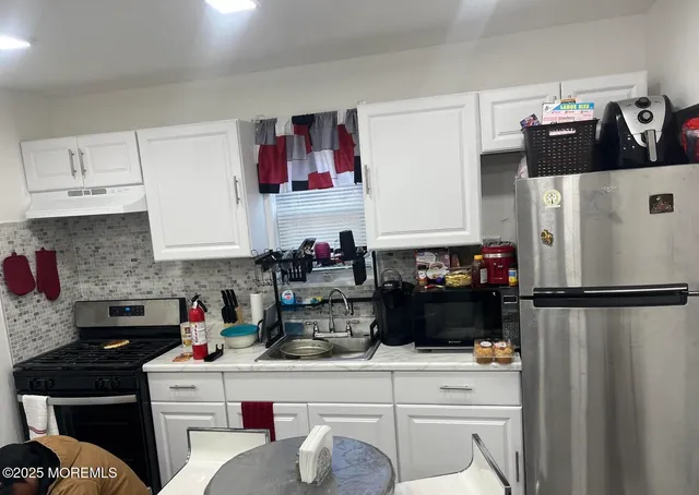 a kitchen with stainless steel appliances a refrigerator and cabinets