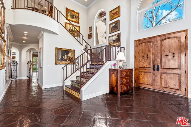 a kitchen with stainless steel appliances a stove top oven a sink dishwasher a dining table and chairs with wooden floor