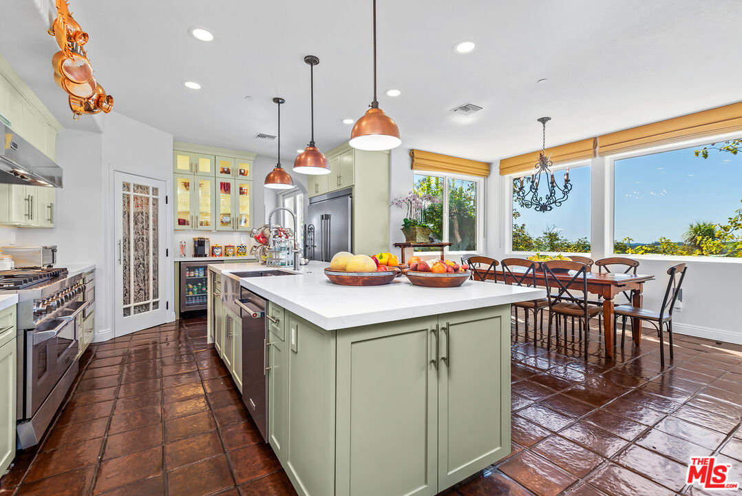 8018 Balcom Canyon Road Somis, CA 93066 - Photo 14 of 36 a kitchen with stainless steel appliances a stove top oven a sink dishwasher a dining table and chairs with wooden floor