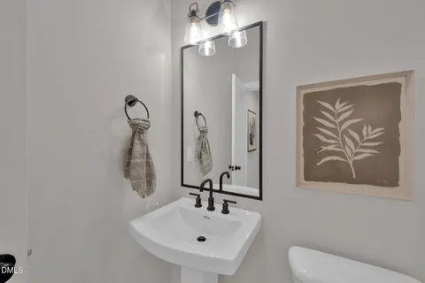 a bathroom with a sink and mirror with toilet
