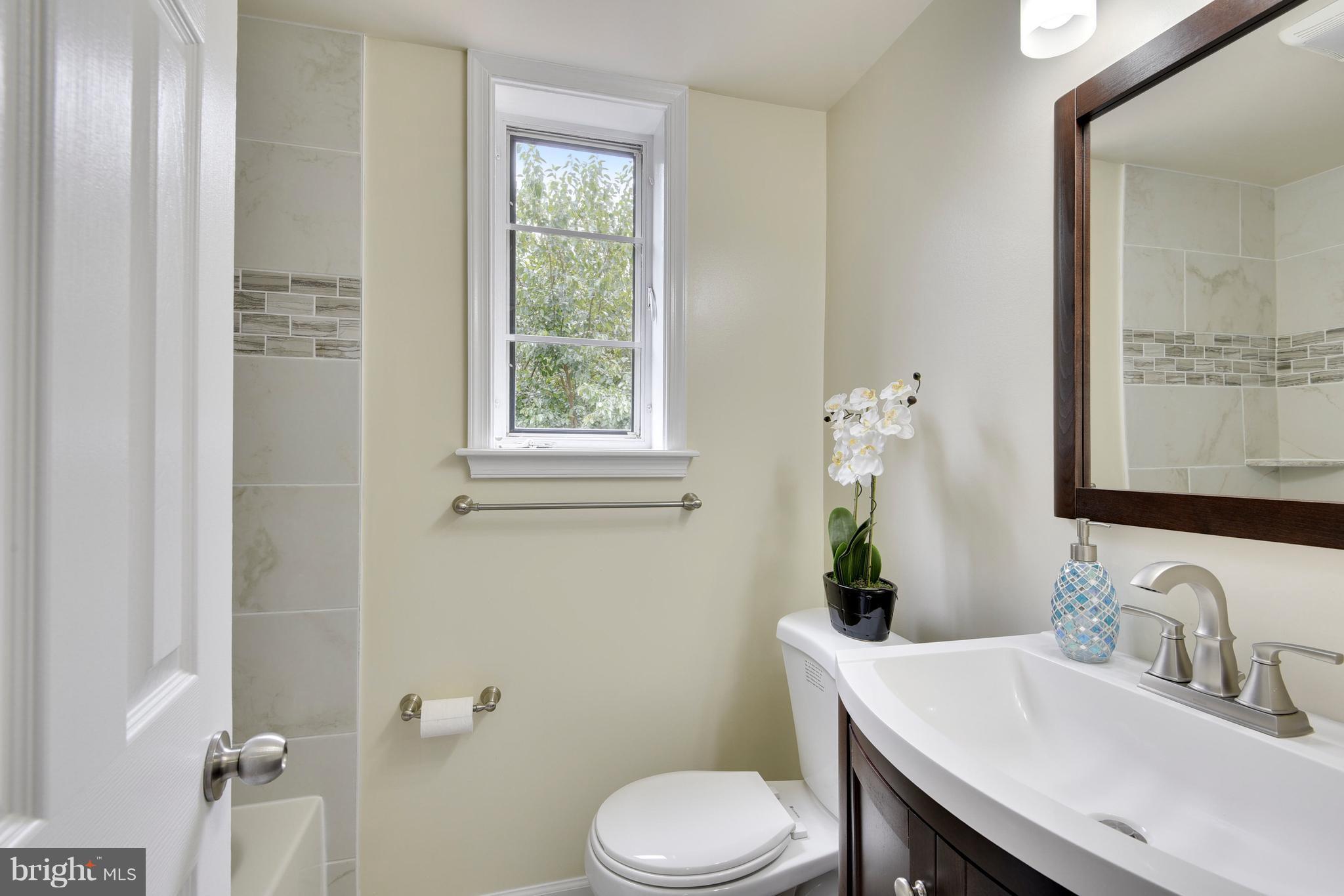 3902 Randolph Road Wheaton, MD 20902 - Photo 13 of 30 a bathroom with a granite countertop toilet sink and mirror