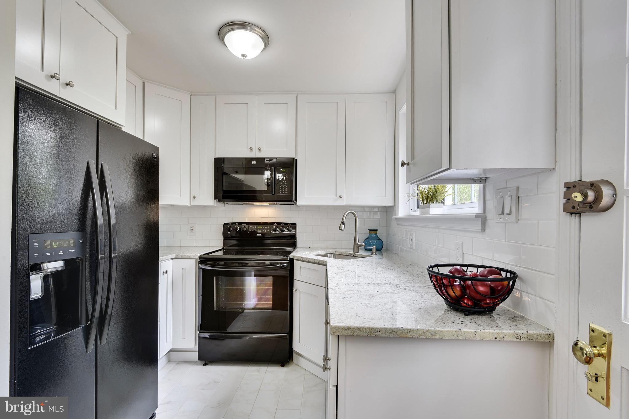 3902 Randolph Road Wheaton, MD 20902 - Photo 10 of 30 a kitchen with stainless steel appliances granite countertop a refrigerator a stove and a sink