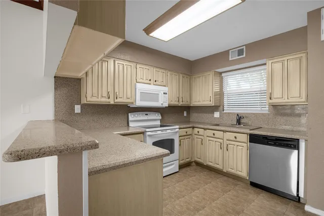 a kitchen with granite countertop cabinets sink and window