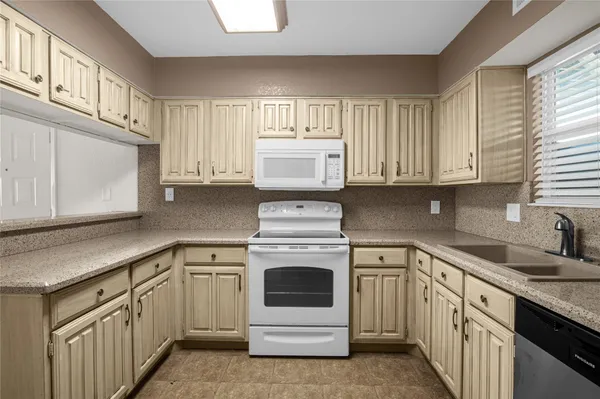 a kitchen with white cabinets and white appliances