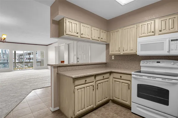 a kitchen with white cabinets and white appliances