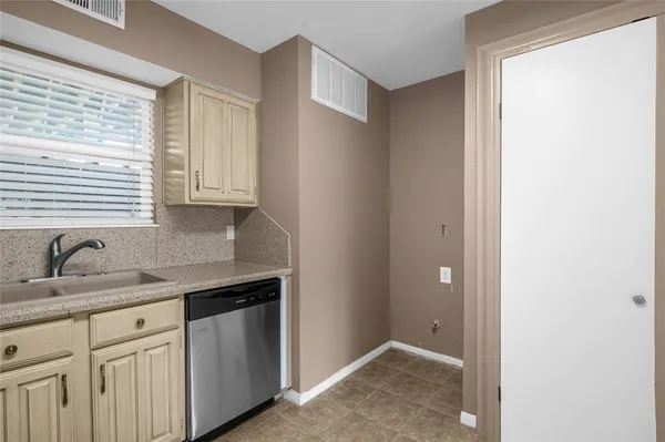 a kitchen with granite countertop white cabinets and window