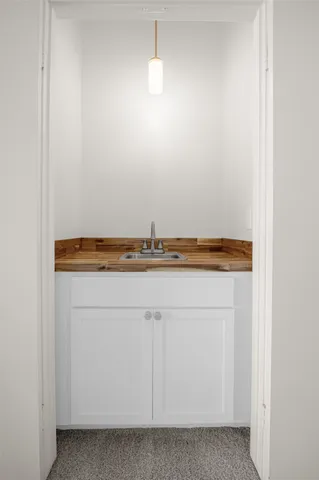 a view of a hallway with wooden floor and a livingroom