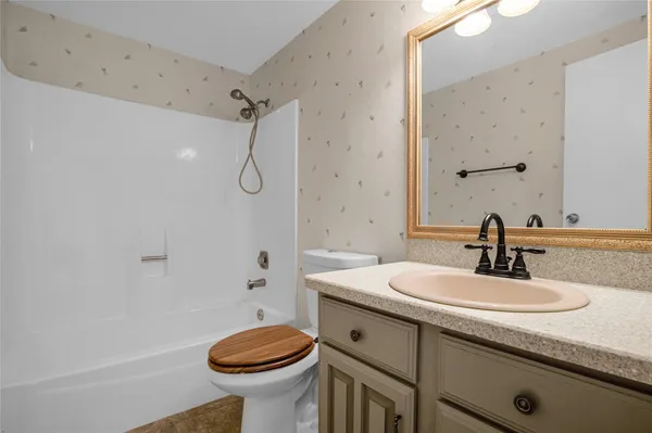 a bathroom with a sink a toilet and shower