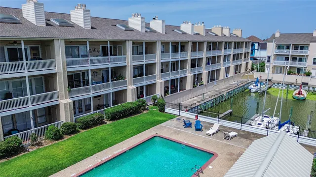 an aerial view of a house with swimming pool a yard and lake view