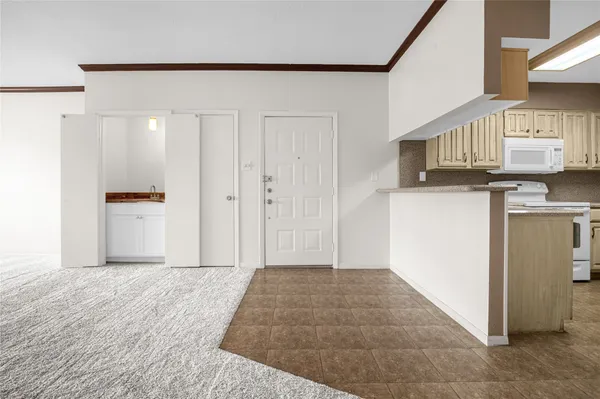 a view of a kitchen with wooden floor and a refrigerator