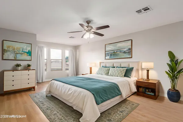 a spacious bedroom with a bed and a chandelier
