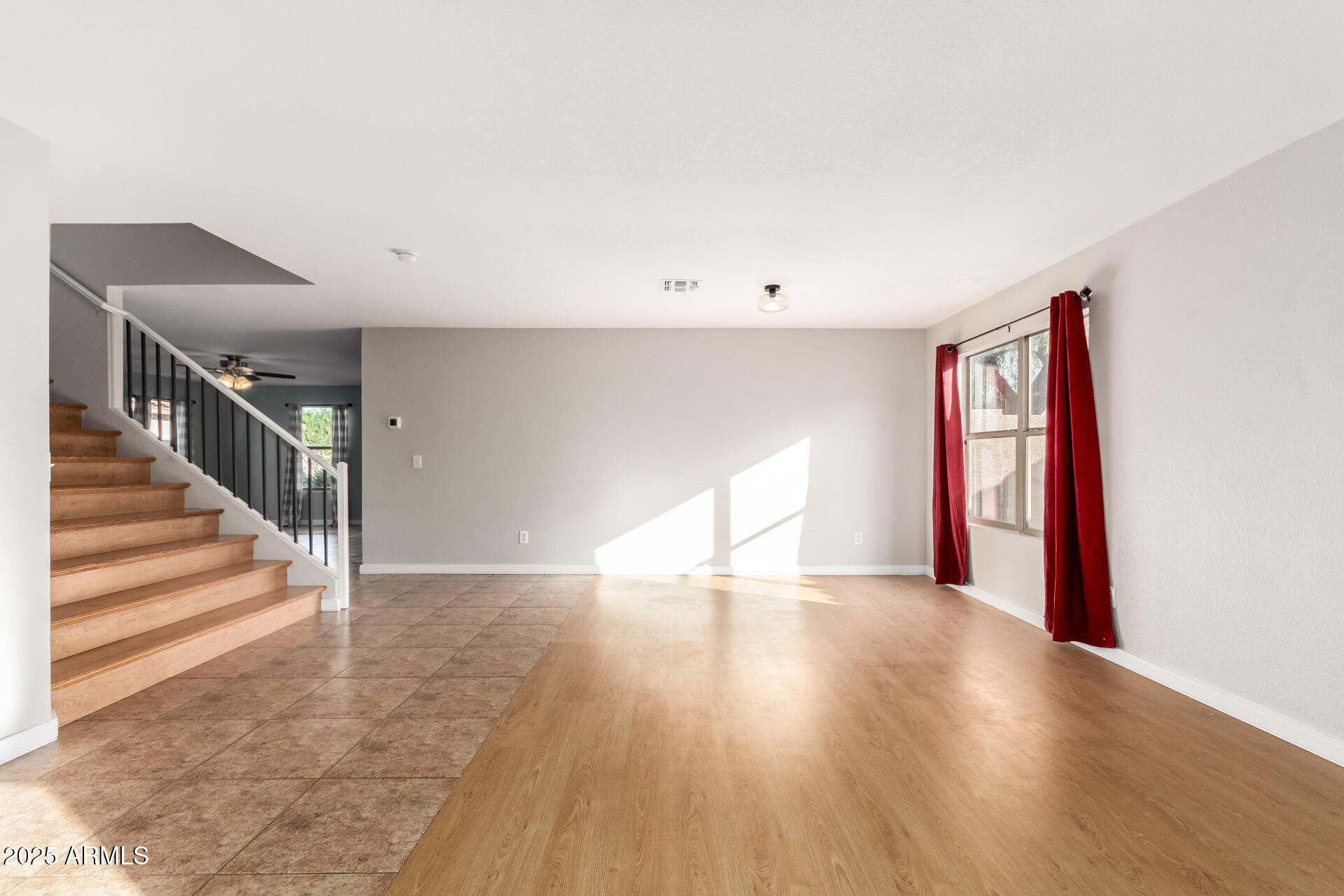 631 South Colonial Court Gilbert, AZ 85296 - Photo 4 of 27 a view of an empty room with wooden floor and stairs