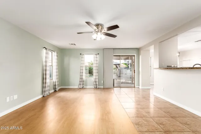 a view of an empty room with window and wooden floor