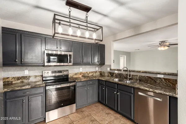 a kitchen with stainless steel appliances granite countertop a sink and stove top oven