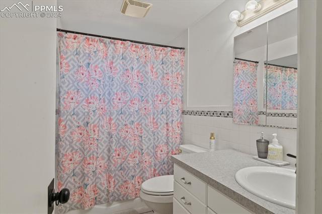 28079 Iris Road Pueblo, CO 81006 - Photo 24 of 50 Bathroom with tile walls, vanity, and toilet