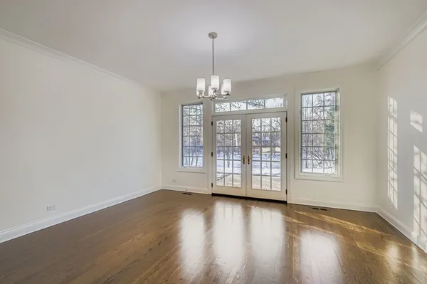 a view of an empty room with wooden floor and wooden floor