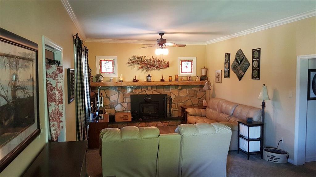 260 Vogel Road Butler, PA 16002 - Photo 3 of 24 The living area features a stone fireplace and a ceiling fan, maximizing its potential for year-round comfort.