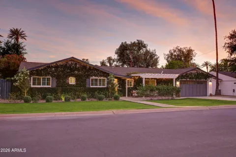 a front view of a house with a yard and trees