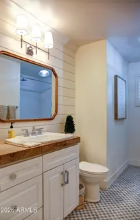 a bathroom with a granite countertop toilet sink and mirror